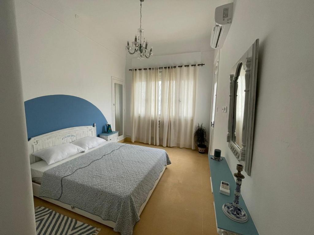 1 dormitorio con 1 cama con cabecero azul y espejo en Nomads Hostel Tunisia en Túnez