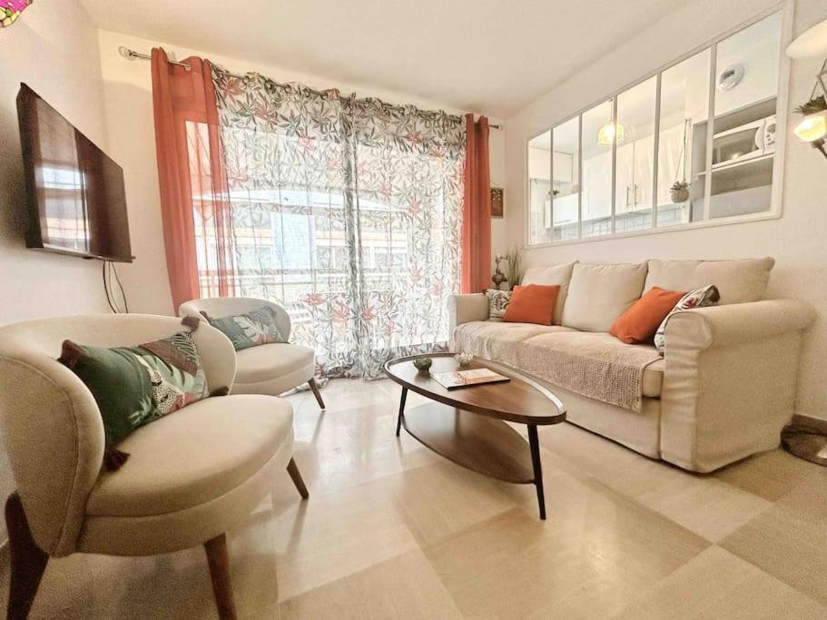 un salon avec un canapé et une table dans l'établissement La Petite Louisiane : Apt 4 Prs, 300 m plages, à Antibes