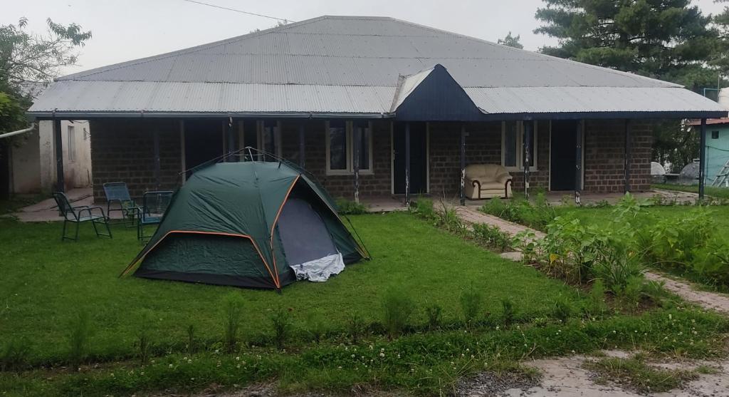 une tente verte en face d'une maison dans l'établissement The Teal Cottage, à Murree