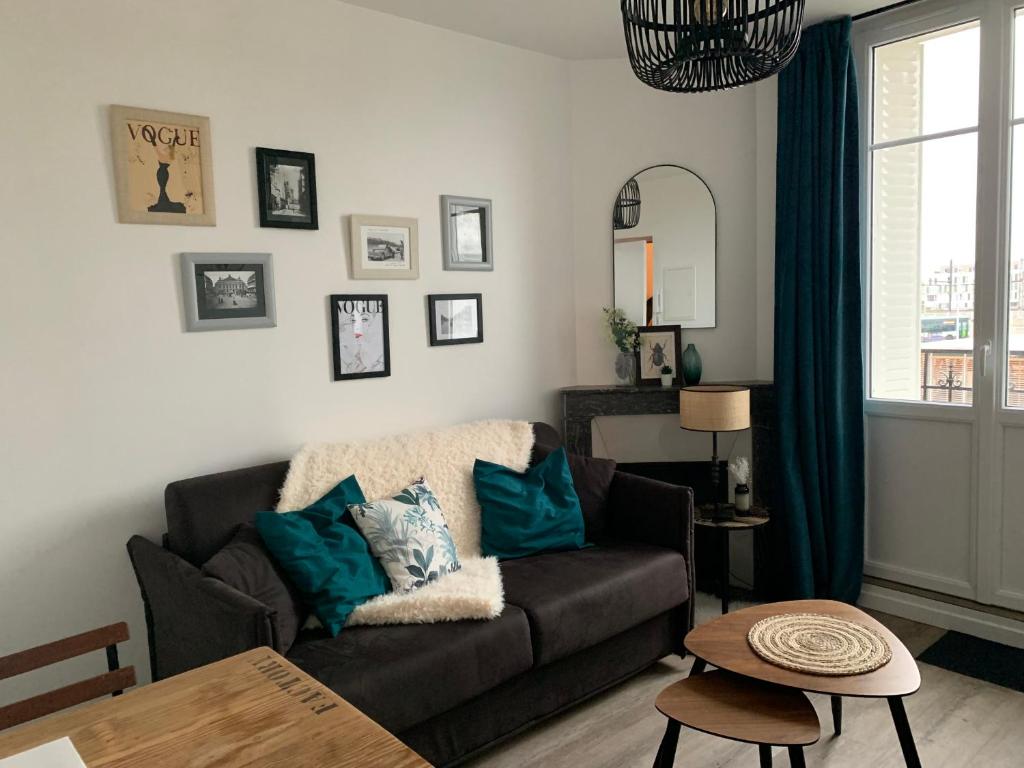 uma sala de estar com um sofá e uma mesa em VILLA GABI em Juvisy-sur-Orge