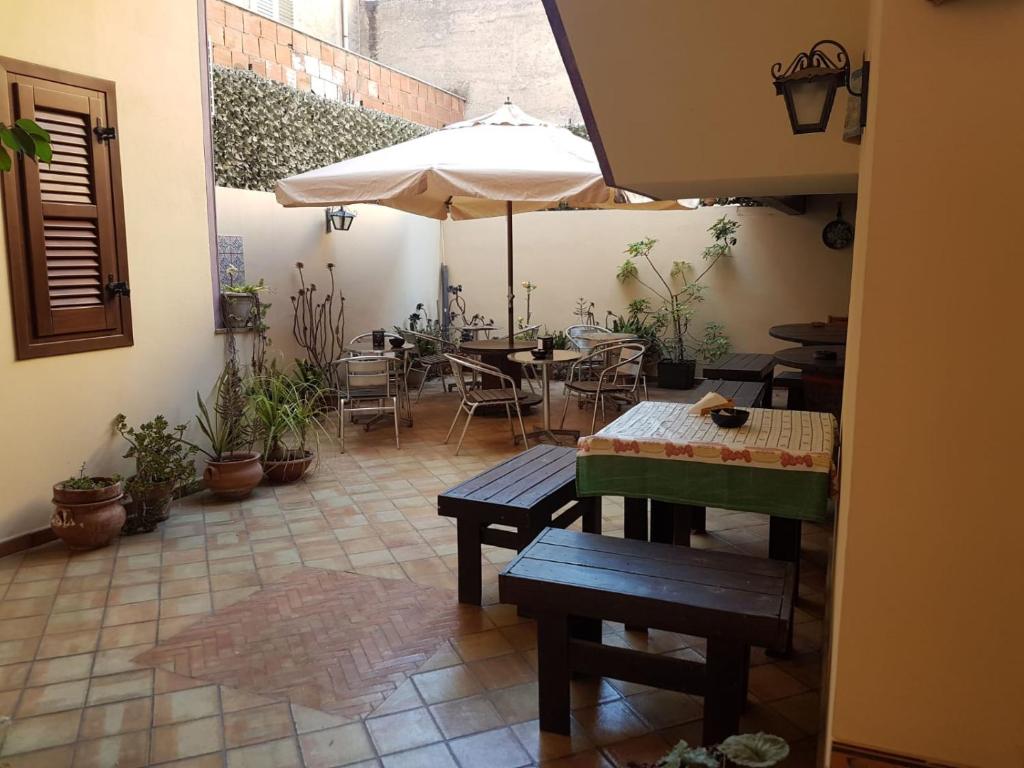 a patio with tables and chairs and an umbrella at Ippocampo B&B in Licata