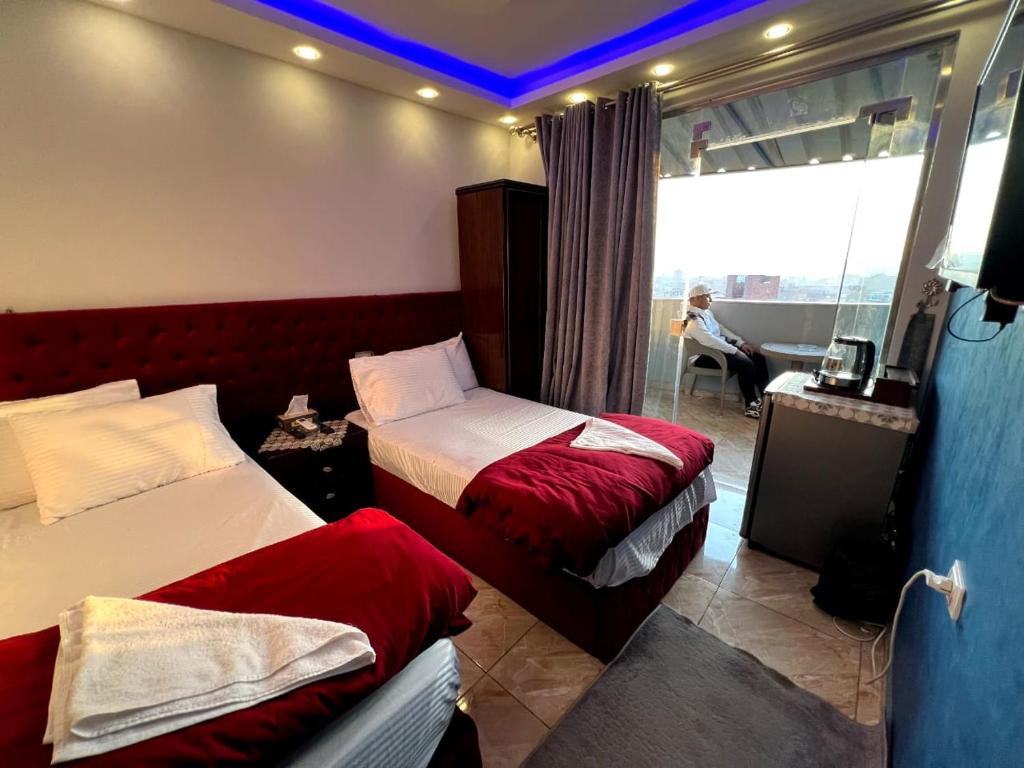 een hotelkamer met 2 bedden en een raam bij Pyramids Orion inn in Caïro