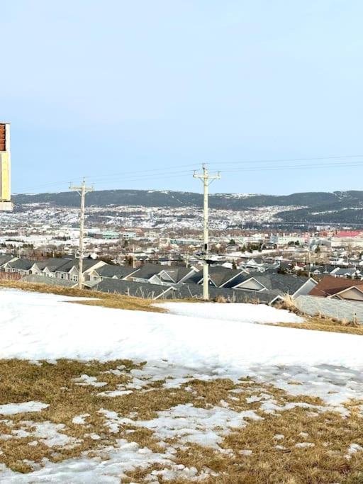 a snow covered field with a city in the background at modern rustic apartment in St. John's