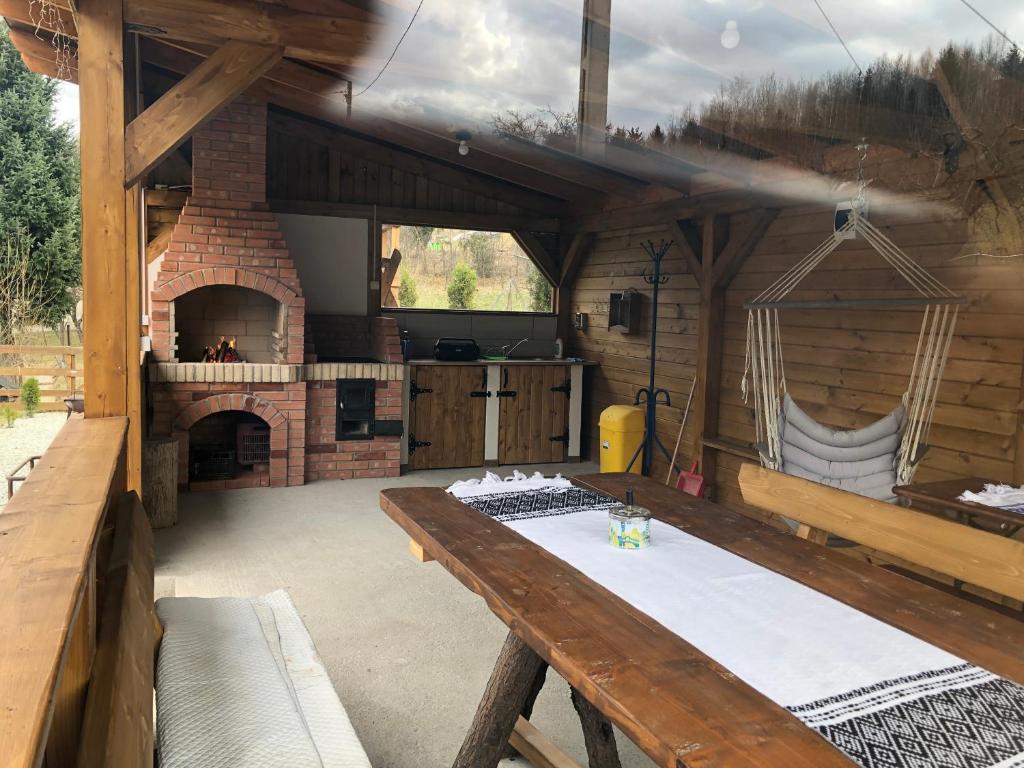 an outdoor kitchen with a table and a fireplace at Cabana La Batranu in Borşa
