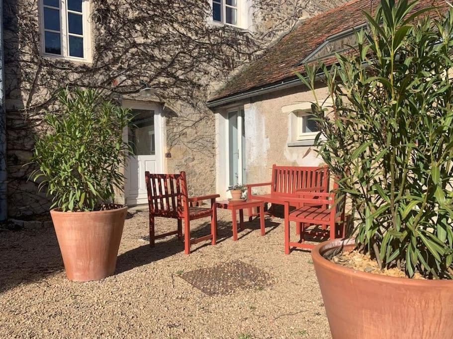 two red benches sitting in front of a building at La maison du Boulanger in Pontaubert