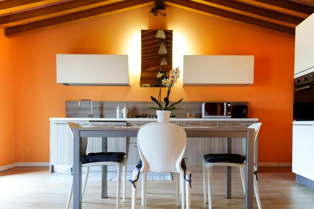 une cuisine orange avec une table et deux chaises dans l'établissement Abano Terme - La Dolce Vita's Villa (comfort & serenity), à Abano Terme