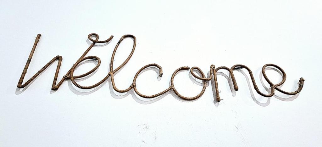 a sign that says welcome on a white wall at Loft del Capataz in San Fernando