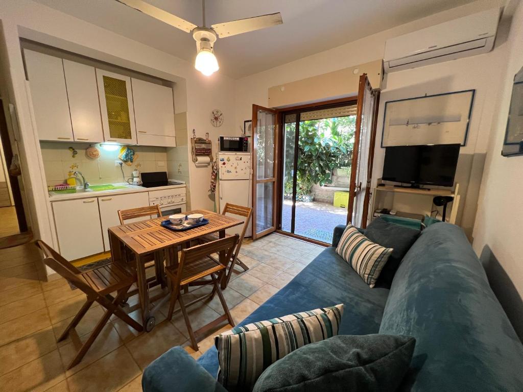 un salon avec un canapé bleu et une table dans l'établissement Casetta Anna, à Santa Marinella