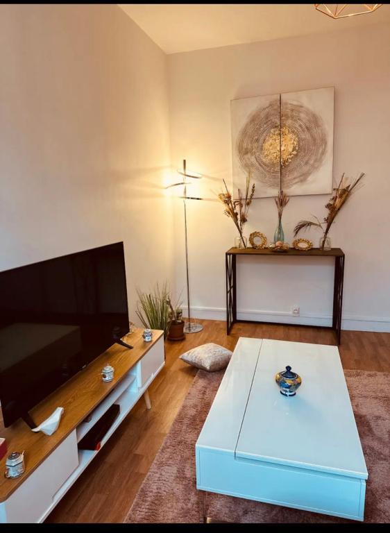 un salon avec une télévision et une table basse dans l'établissement Appartement Paris centre, à Paris