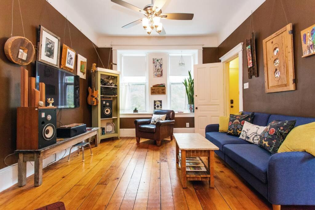 uma sala de estar com um sofá azul e uma mesa em iKlektik House // BlueJay em Chicago