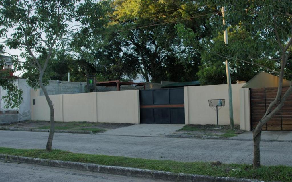 une clôture blanche avec un panier de basket en face d'une maison dans l'établissement LA CASA DE AL LADO, à Mercedes
