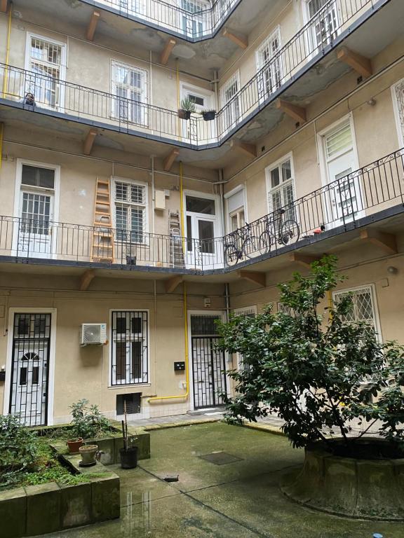 a building with balconies and a tree in the courtyard at Dembinszky utca in Budapest