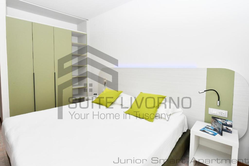 a bedroom with a white bed and a side table at Suites Marilia Apartments - Suite Livorno Holiday Home Group in Livorno