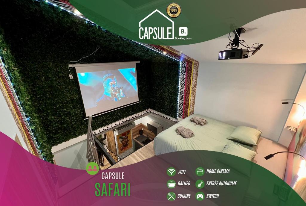 een kamer met een bed en een projectiescherm bij Capsule Safari - Jacuzzi - Nintendo Switch - Netflix & Home cinéma - Pouf géant - Filet suspendu in Douai