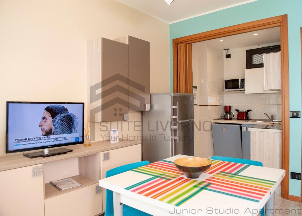 a room with a table and a tv in a kitchen at Suites Marilia Apartments - Suite Livorno Holiday Home Group in Livorno