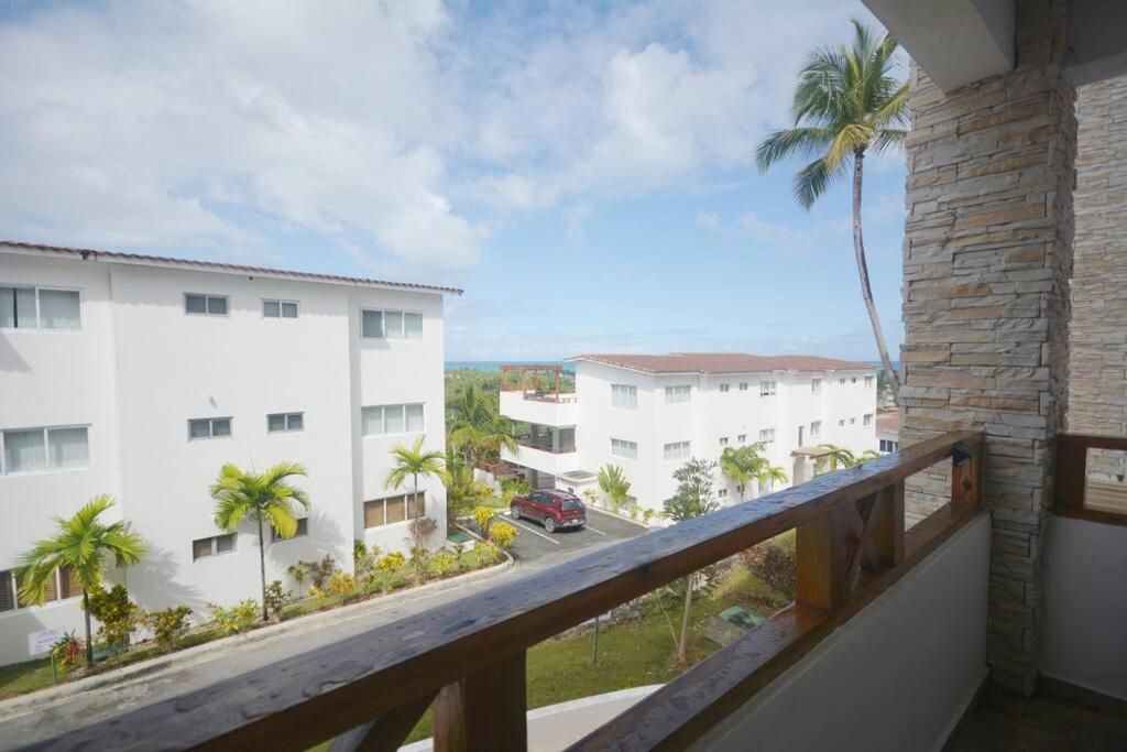 a balcony with a view of a street and palm trees at Magnifique appartement vue mer in Las Terrenas
