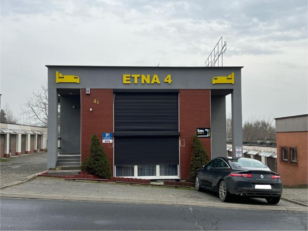 a car parked in front of a building with a garage at Etna 4 - Apartamenty -Parking Osmeckiego 4 E Rzeszów -Parking -Garaż- in Rzeszów