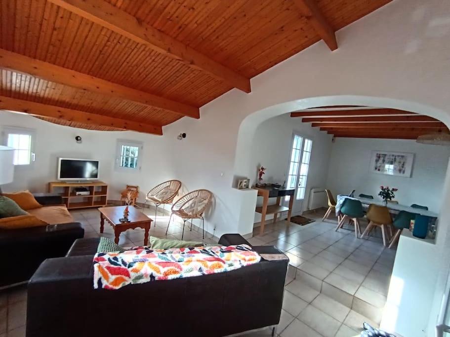 ein Wohnzimmer mit einem Sofa und einem Tisch in der Unterkunft Maison 4 ch*L'Aiguillon s/ Mer in LʼAiguillon-sur-Mer