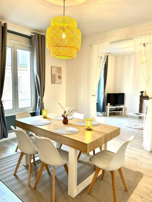 une table à manger et des chaises dans un salon dans l'établissement L Étoilé Appartement tout confort à Epinal Gare Classé 3 étoiles, à Épinal