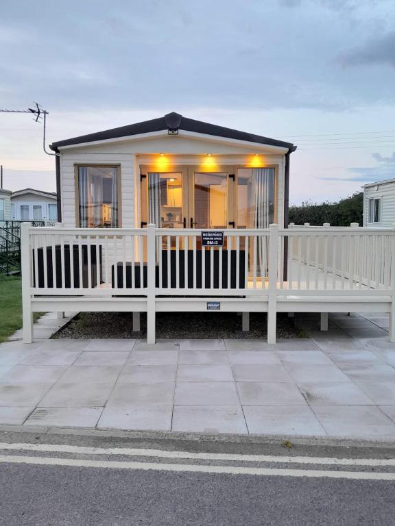 a small white house with a white fence at Sunnymeade Holiday Park i3 St David in Ingoldmells