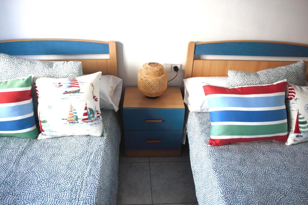 1 dormitorio con 2 camas con almohadas y mesita de noche en MAR DE FORA, en Cambados