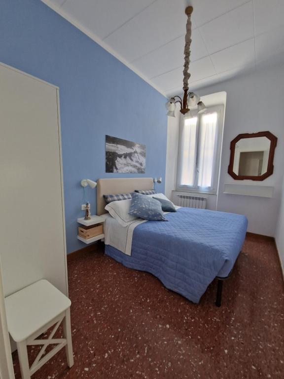 a blue bedroom with a bed and a mirror at Ancora qui, nel Golfo dei Poeti in La Spezia