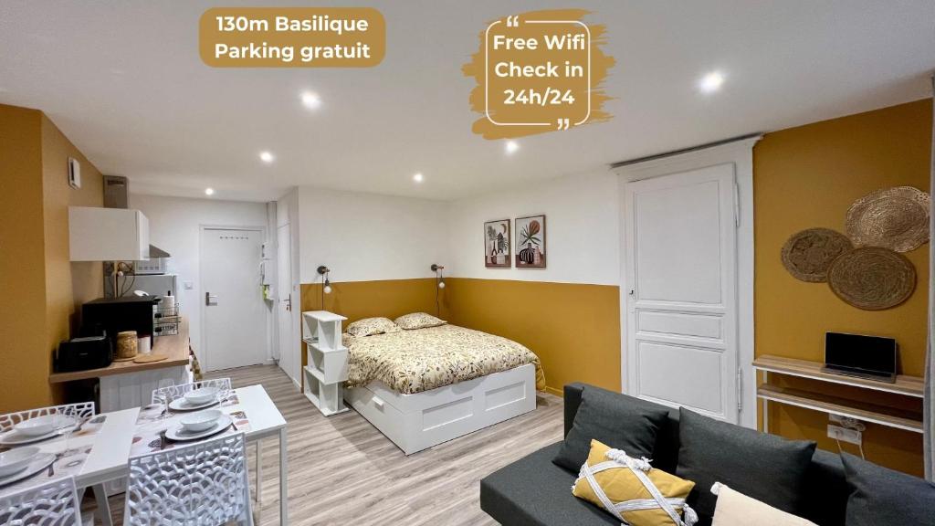 1 dormitorio con 1 cama y sala de estar con sofá en La Palmeraie, en Brioude