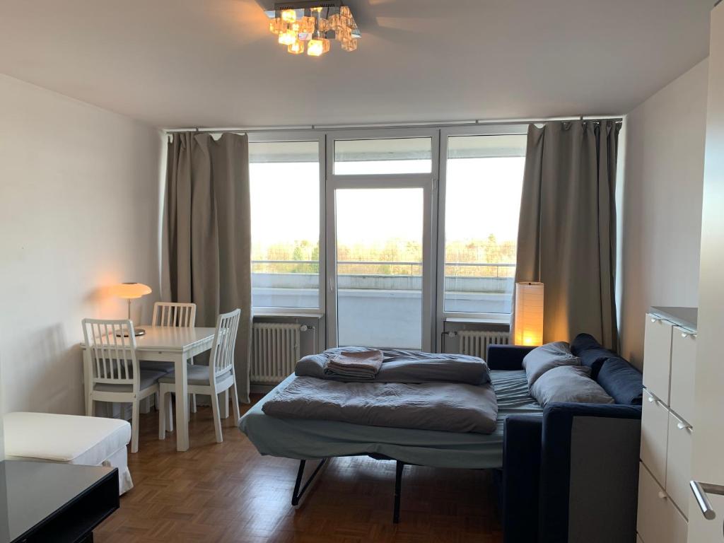 - une chambre avec un lit, une table et une salle à manger dans l'établissement Business Apartment SPA walk to Fair & Rhine River, à Düsseldorf