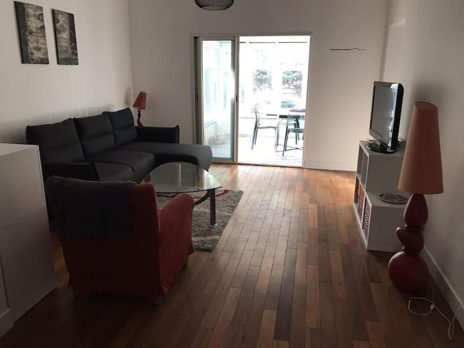 un salon avec un canapé, une télévision et une table dans l'établissement Appartement au cœur de Cannes, à Cannes