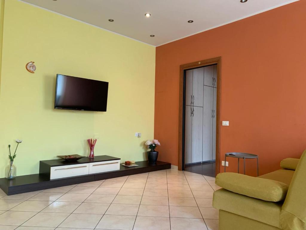 a living room with a couch and a tv on the wall at Casa di Bea in Merate