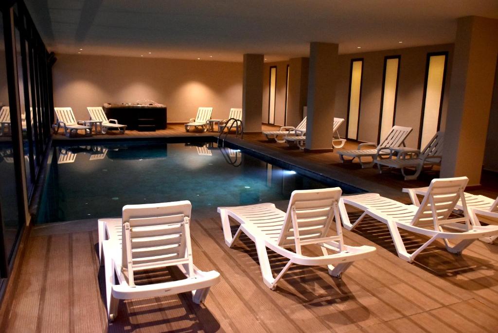 einen Pool mit Liegestühlen und einem Billardtisch in der Unterkunft L'escale Hôtel & Spa By 7AV HOTELS in Ouazzane