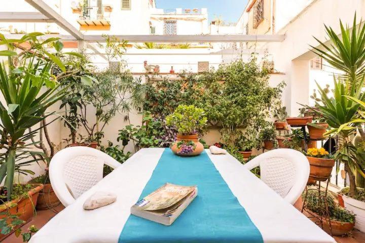 a table with a blue table cloth on a patio at In the Heart Of The Kalsa! Two Apartemts Free Park, No ZTL ! Ideal for remote work! in Palermo