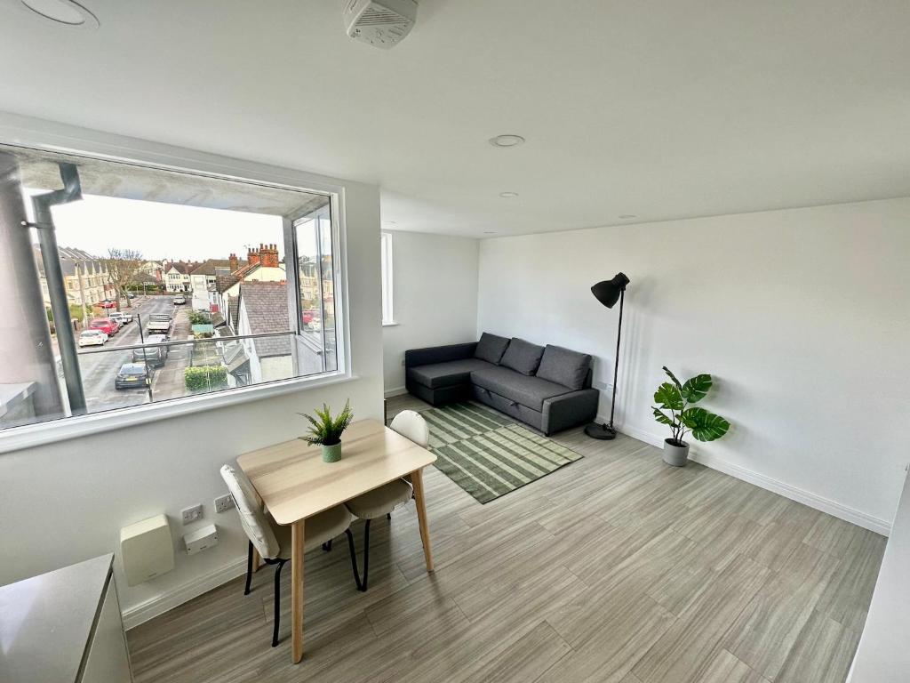 a living room with a couch and a table at Modern Flat in Leigh Broadway in Leigh-on-Sea