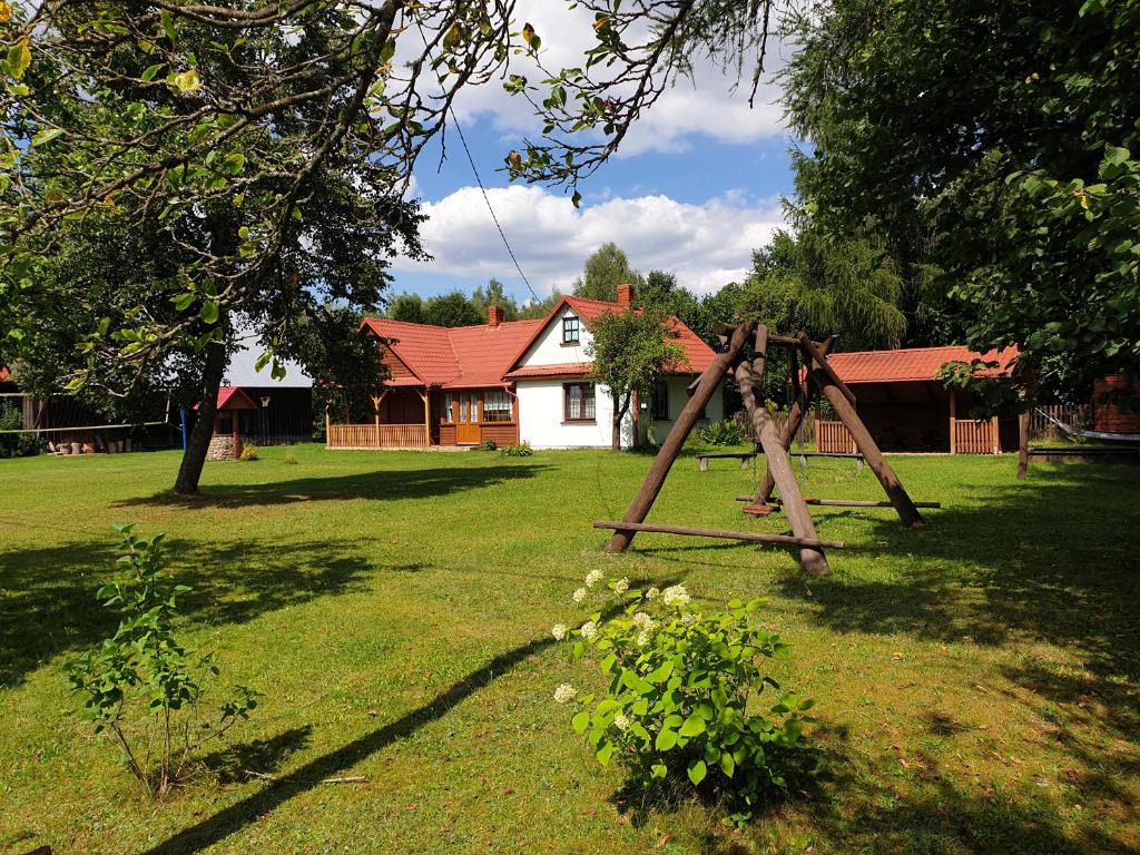 estructura de madera en un patio con una casa en Leśny domek, en Białowieża