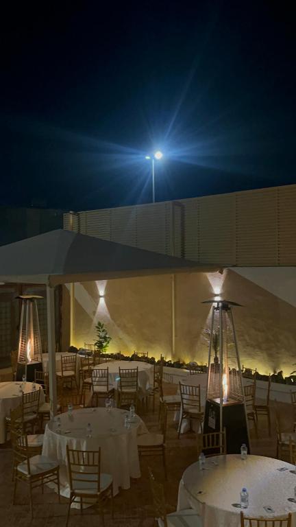 um grupo de mesas e cadeiras com luz à noite em شاليه فرحتي em Al Madinah