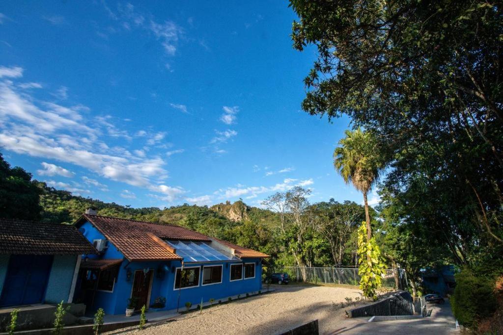 裴尼多的住宿－Pousada Paris Hostelli，前面有棕榈树的蓝色房子