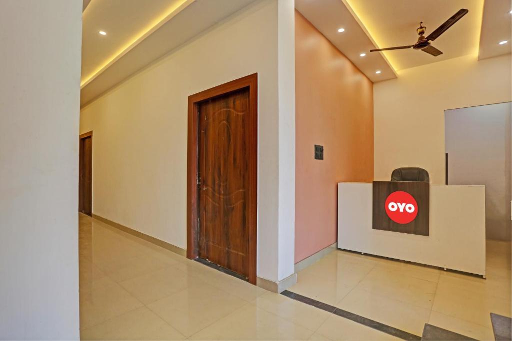 a hallway with a door and a sign on the wall at North Hotel & Lawn in Lucknow