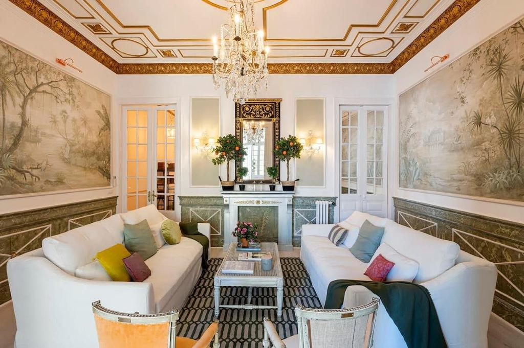 una sala de estar con 2 sofás blancos y una lámpara de araña en Placa Catalunya V Charming and Exquisite 5Bd Apartment with Large Balcony, en Barcelona