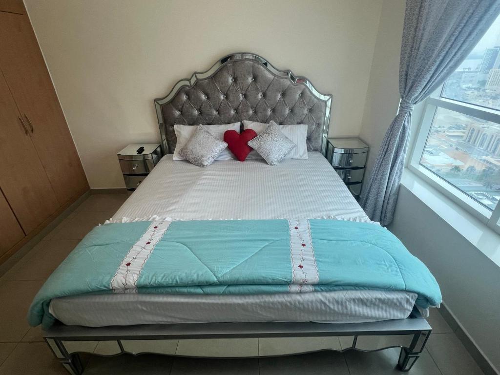 Una cama con dos corazones rojos encima. en F22,R2 Sea&city view room in three bedroom apartment, separate bath outside, en Ajman