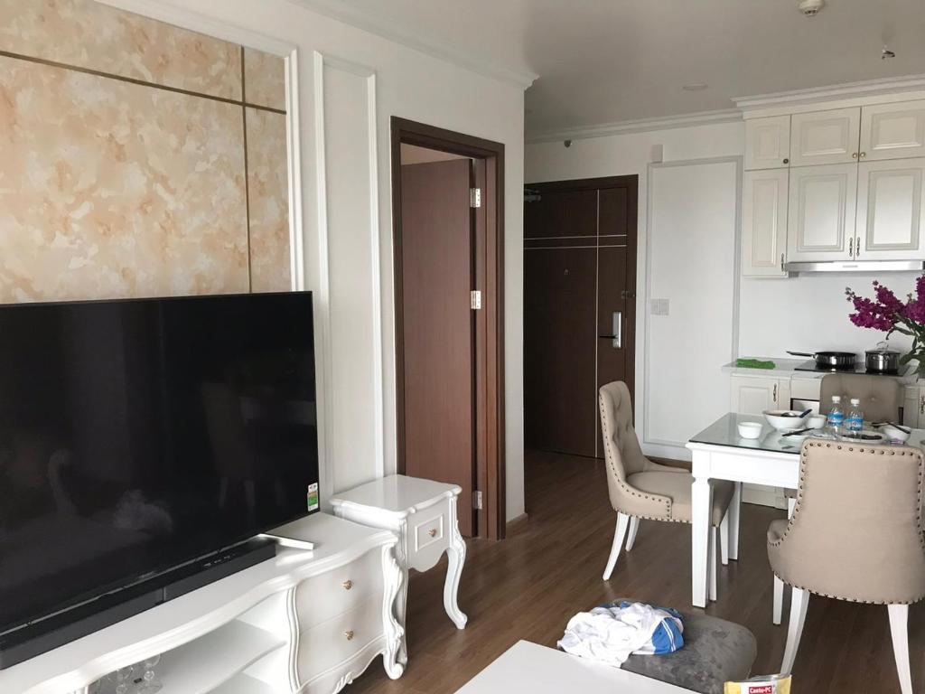 a living room with a large flat screen tv and a table at S1-05A11A-Sapphire Hạ Long in Ha Long