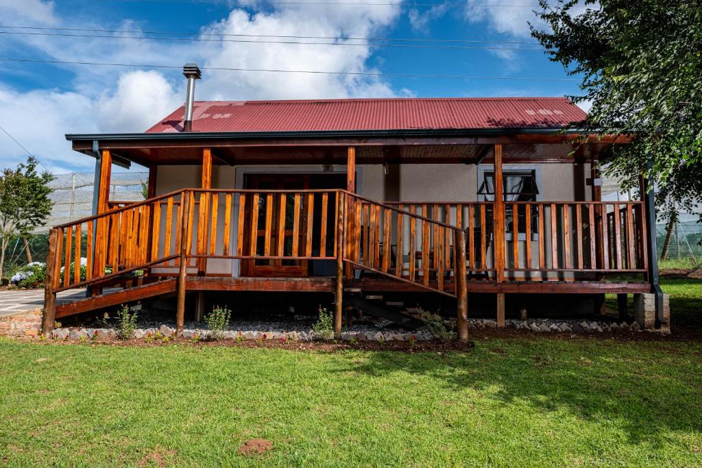 une maison avec une grande terrasse en bois dans la cour dans l'établissement Seloko Guest Cottage, à Polokwane