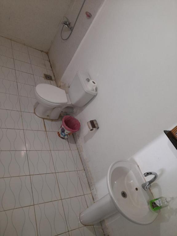 a bathroom with a toilet and a sink at Tigana Ka in Naj‘ Tinjār
