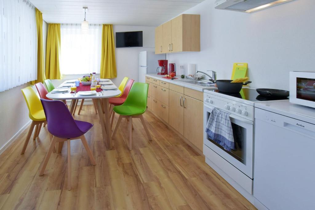 a kitchen with a table and colorful chairs at House of the Rising Fun in Bubesheim
