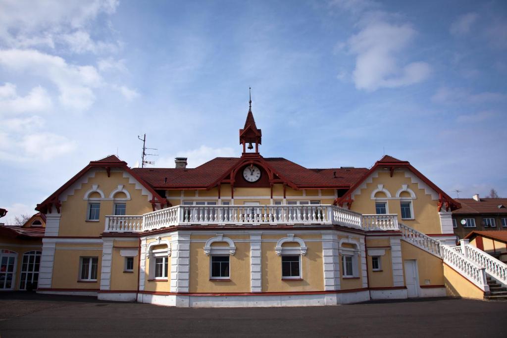 un gran edificio amarillo con un reloj encima en Hotel U Simla, en Karlovy Vary