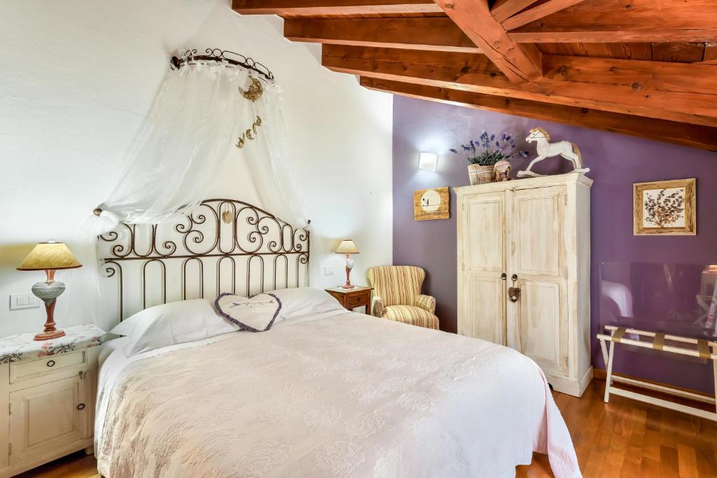 a bedroom with a white bed and purple walls at Affittacamere La Collina Degli Ulivi in La Spezia