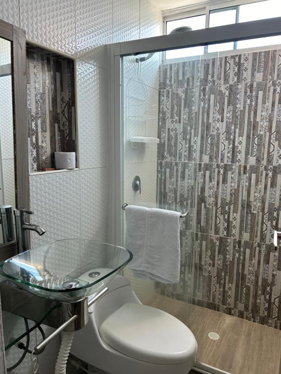 a bathroom with a glass table and a shower at Hotel Sun Suite in Barranquilla