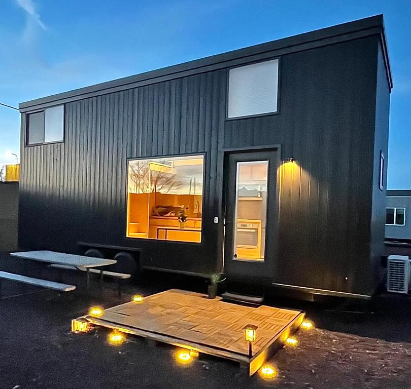 ein schwarzes winziges Haus mit Lichtern auf einem Parkplatz in der Unterkunft Tiny home near Grand Canyon sleeps 5, epic views! in Flagstaff