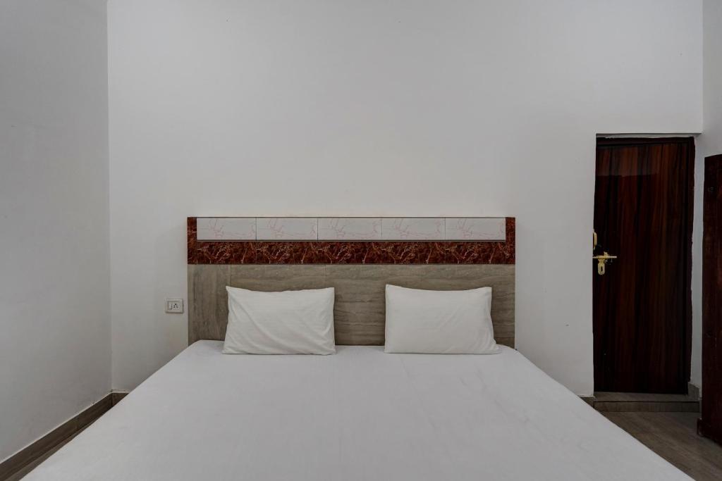 1 dormitorio con 1 cama blanca grande con almohadas blancas en OYO Sky Line, en Ghaziabad