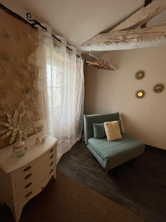Charmante maison, vue imprenable في Nanclars: غرفة معيشة مع أريكة خضراء وطاولة