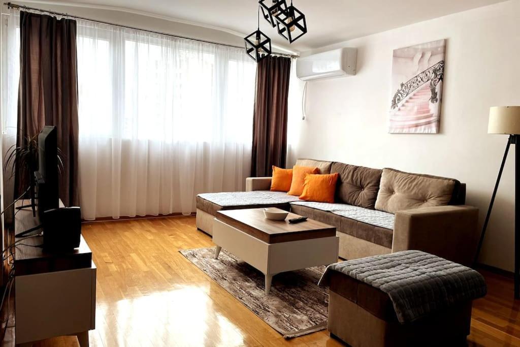 - un salon avec un canapé et une table dans l'établissement Tiffany Apartments in Skopje, à Skopje